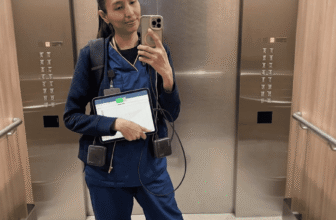 Nurse Darleene taking an elevator mirror selfie in blue scrubs, carrying the compact charger featured in our Anker Nano 10K review.