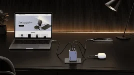 UGREEN Nexode Pro 65W charger powering a laptop, smartphone and wireless earbuds in a modern desk workspace.