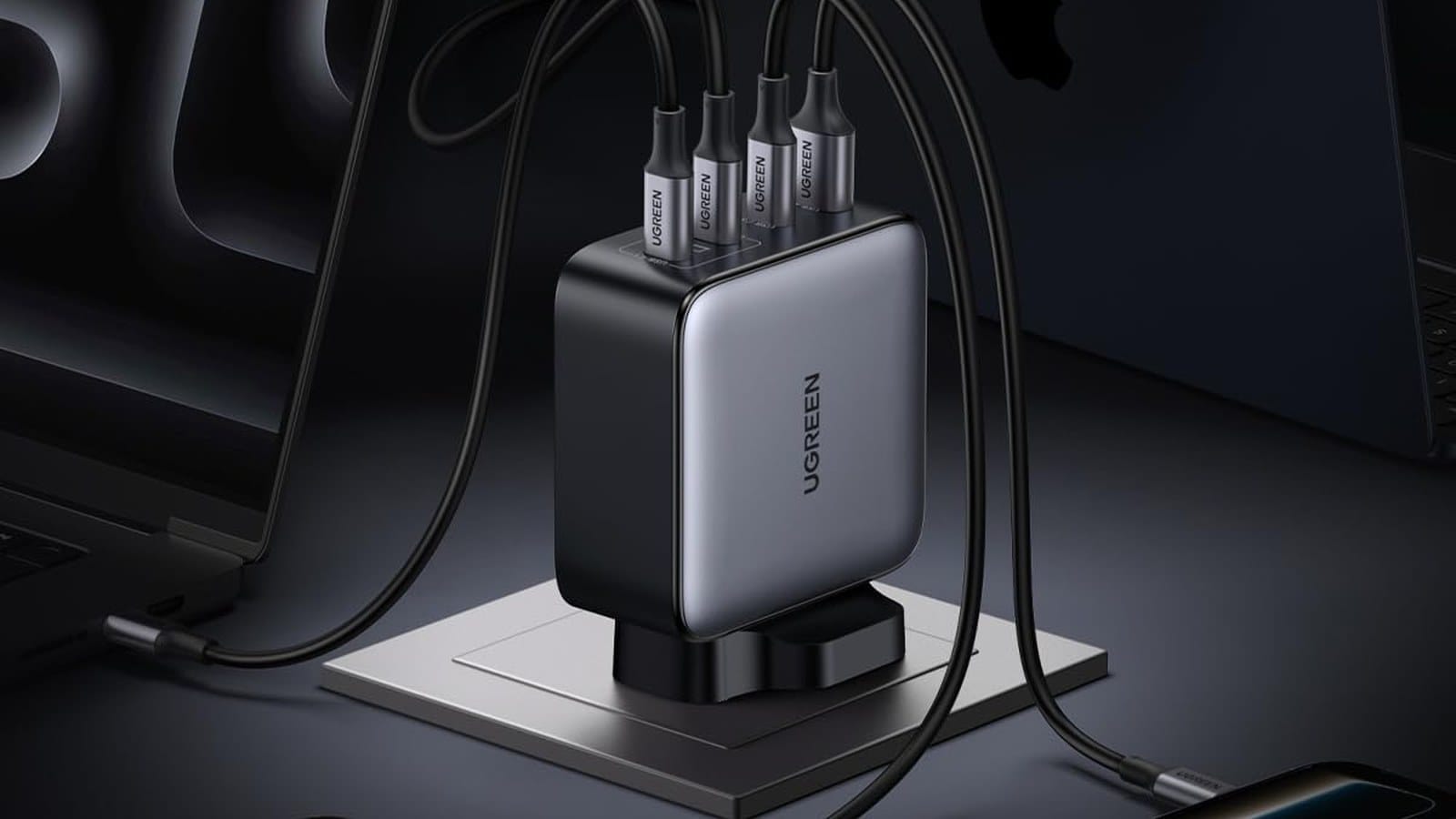 UGREEN Nexode 200W 3C1A GaN charger with four cables connected, charging two laptops on a desk